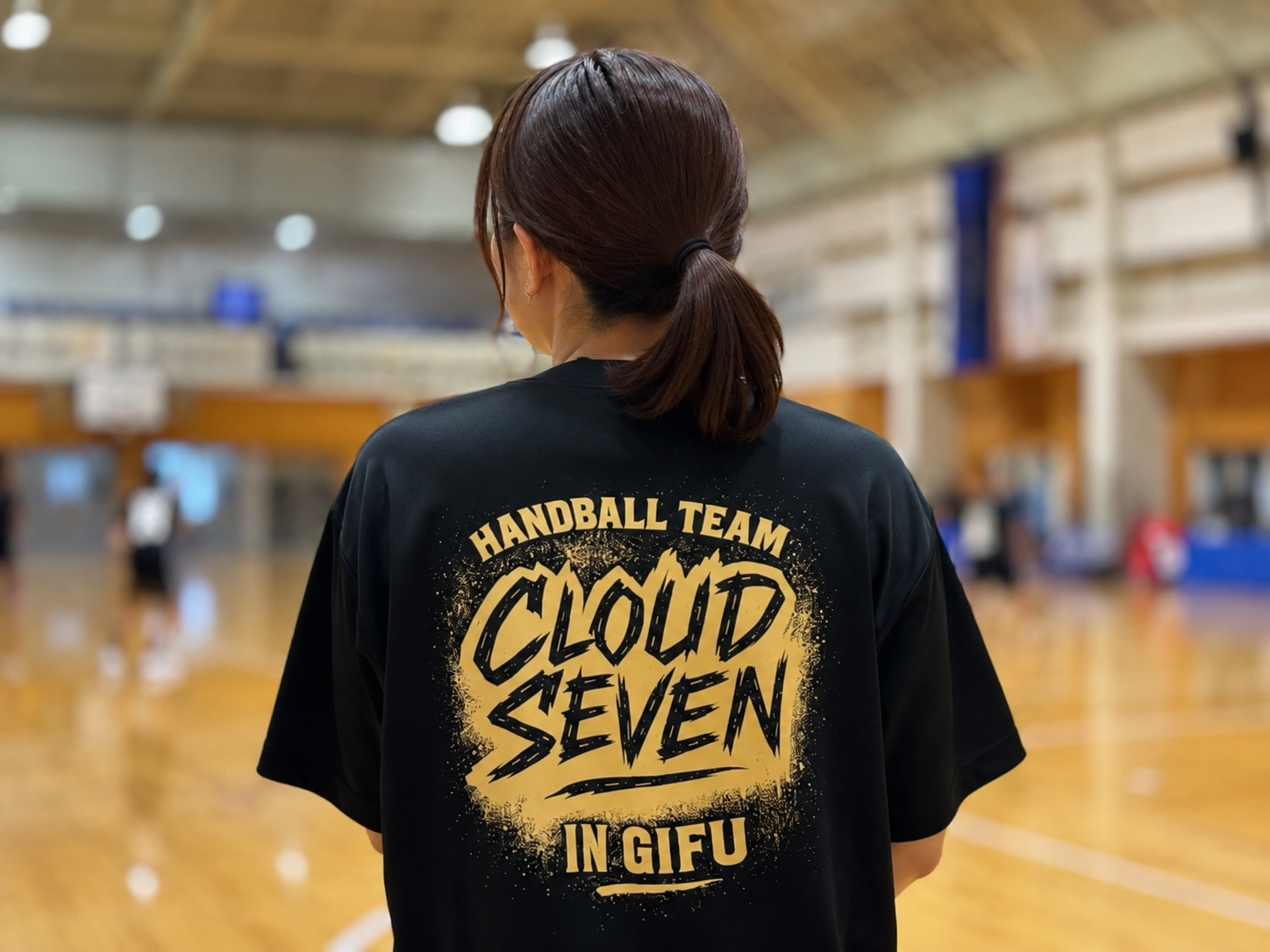 CLOUD SEVENのTシャツを着て体育館を見つめる保護者の後ろ姿